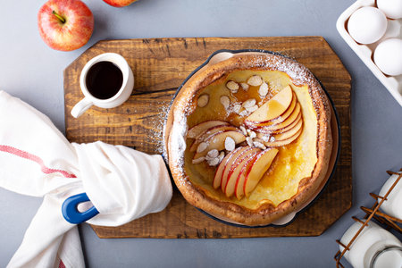 Dutch baby pancake with apples, powdered sugar and almondsの素材