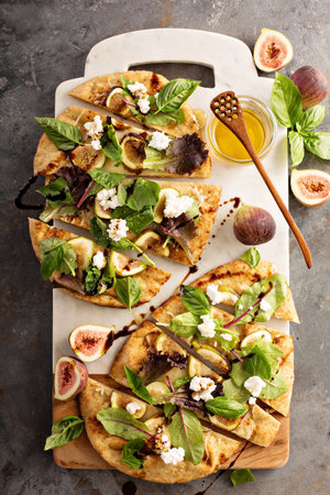 Flatbread fall pizza with balsamic, figs, cheese and salad leavesの素材