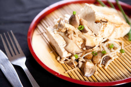 tofu steak with mushroom and soy sauce on black backgroundの写真素材