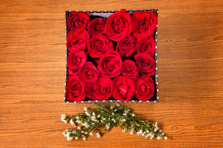 Red rose in black gift box on wood tableの写真素材