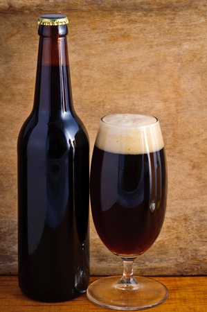 Glass and bottle of dark beer on a wooden backgroundの写真素材