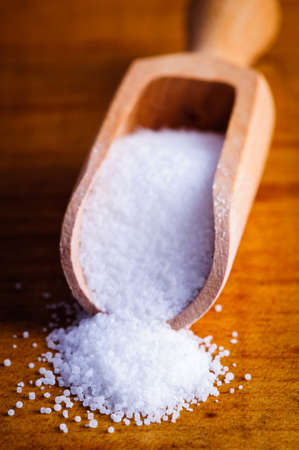 Background with natural sea salt in wooden spoonの写真素材