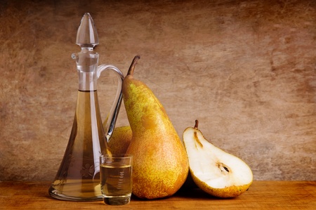 traditional fruit brandy and pears on a vintage grunge wooden backgroundの写真素材