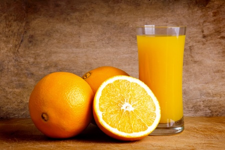 sill life composition with glass of fresh orange juice with oranges on a vintage woodenbackgroundの写真素材