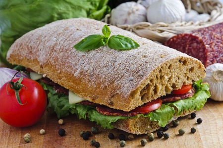 ciabatta sandwich with salami, cheese and vegetablesの写真素材