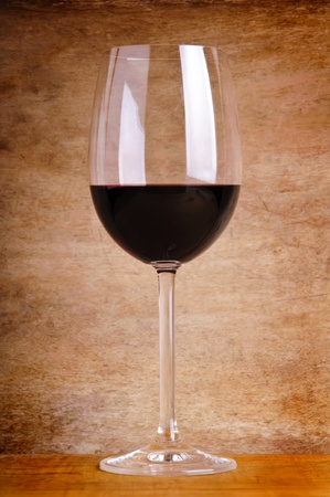 glass of red wine on a vintage wooden backgroundの写真素材