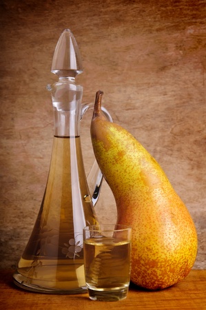 still life composition with traditional alcoholic drink and pear fruit on a vintage wooden backgroundの写真素材
