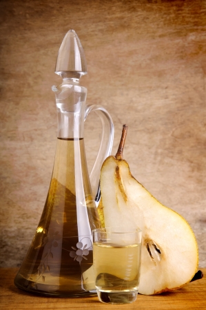romanian traditional fruit brandy and pear on a vintage wooden backgroundの写真素材