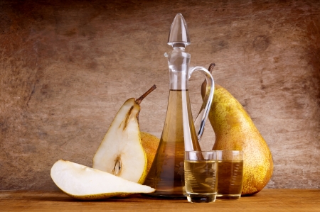 still life composition with fruit brandy and pears on a wooden vintage backgroundの写真素材