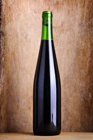 bottle of red wine on a vintage grunge wooden backgroundの写真素材