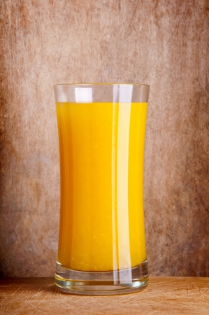 glass of fresh orange juice on a wooden backgroundの写真素材