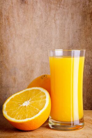 still life with fresh orange juice on a vintage wooden backgroundの写真素材