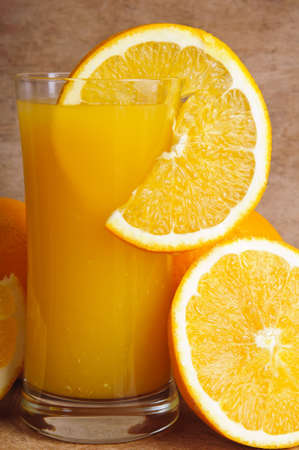 close up glass of fresh orange juice with slice of orange on a vintage wooden backgroundの写真素材