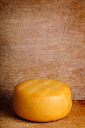 yellow smoked cheese on a vintage grunge wooden background with copy spaceの写真素材