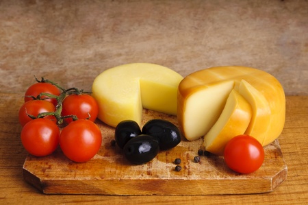 traditional cheese with cherry tomatoes and olives on a wooden backgroundの写真素材