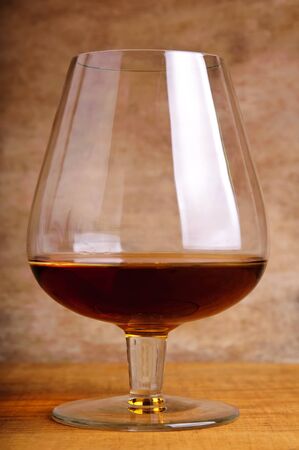 glass of brandy on a vintage wooden backgroundの写真素材