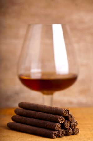 close up of cigars with glass of cognac in backgroundの写真素材