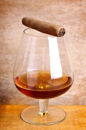 glass of cognac and cigar on a wooden backgroundの写真素材