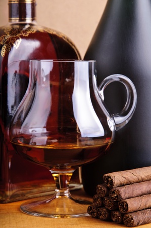 glass and bottle of brandy with cigarillosの写真素材