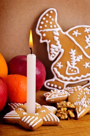home made traditional gingerbread with fruits, candle and walnutsの写真素材