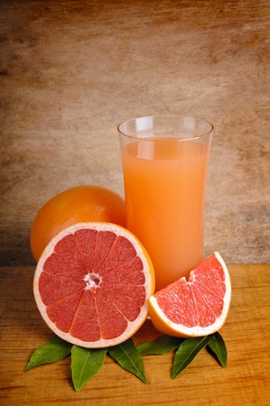 glass of fresh ink grapefruit juice and grapefruits on a wooden backgroundの写真素材