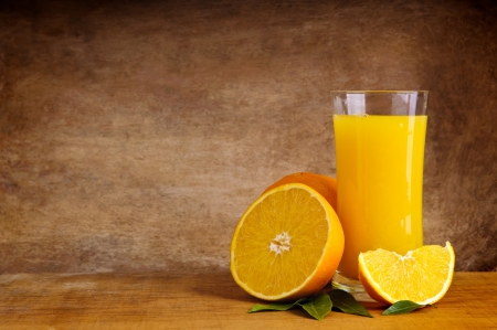 glass of orange juice and fruits with copy space against wooden backgroundの写真素材