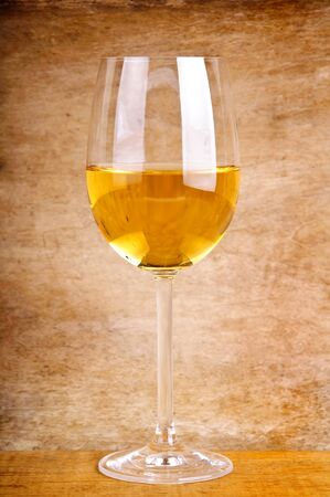 glass of white wine on a wooden backgroundの写真素材