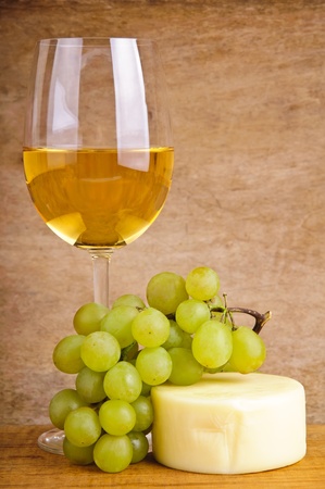 still life composition with glass of white wine, grapes and cheeseの写真素材