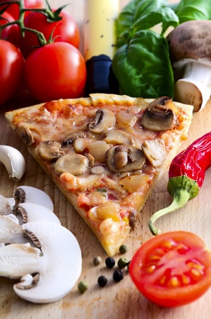 pizza slice and ingredients on a wooden backgroundの写真素材