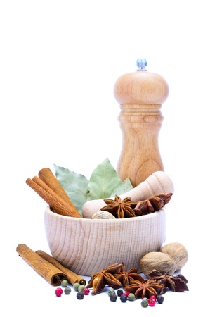different spices with mortar, pestle and pepper mill isolated on a white backgroundの写真素材