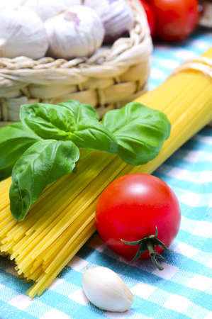 italian pasta ingredients with spaghetti, garlic, basil and tomatoの写真素材