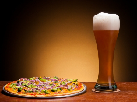 fresh draght beer and pizza with vegetablesの写真素材