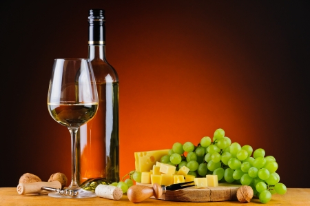still life with glass and bottle of white wine, cheese and grapesの写真素材