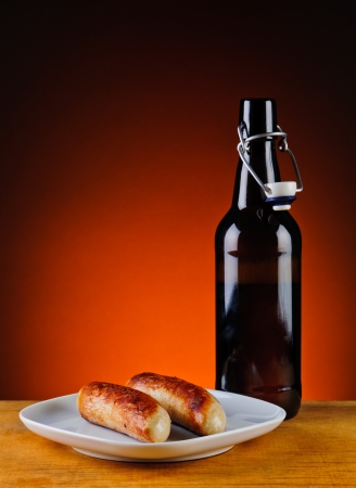 still life with grilled sausages and bottle of beerの写真素材