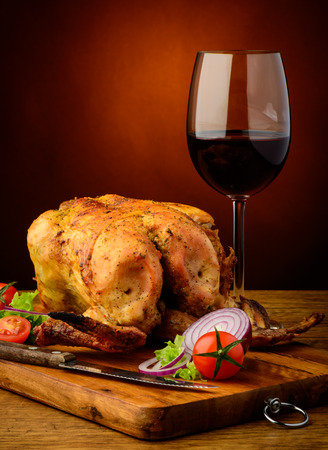 still life with traditional grilled chicken and glass of red wineの写真素材