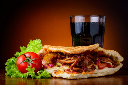 still life with doner kebab, fresh vegetables and cola drinkの写真素材
