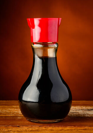bottle of soy sauce closeup on a wooden plateの写真素材