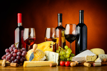 still life with cheese, grapes, red, white and rose wineの写真素材
