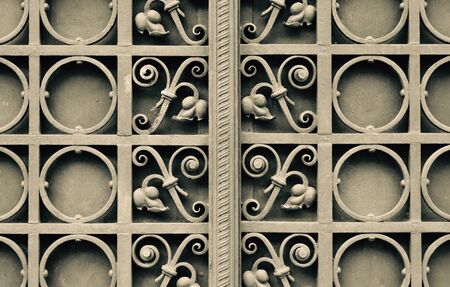 Close up detail of metal gate in black white sepia color filter with iron floral patternの写真素材