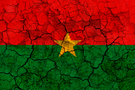 burkina faso country flag symbol painted on a cracked grungy wall. Concept of drought, hardship, no rain or economic crysisの写真素材
