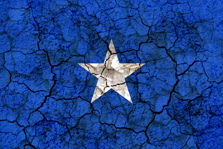 somalia country flag symbol painted on a cracked grungy wall. Concept of drought, hardship, no rain or economic crisisの写真素材