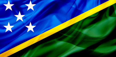 The Solomon Islands country flag symbol on silk or silky waving texture. Smooth fabric or materialの写真素材