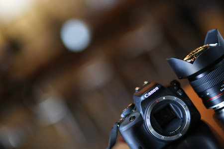 Bucharest, Romania - January 1, 2020: Professional Canon DSLR camera with Samyang ultrawide lens on a table. Lens mount is openのeditorial素材