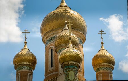 Classic Russian Christian Orthodox church golden plated close up with cross and cloudsの写真素材