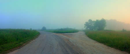 Countryside crossroads at foggy summer morningの写真素材