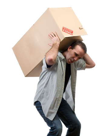 A young man lifting a larg heavy box, isolated against a white backgroundの写真素材