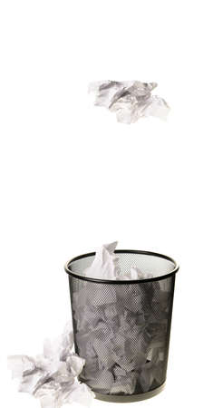 Paper being tossed into a garbage can, isolated on a white background の写真素材