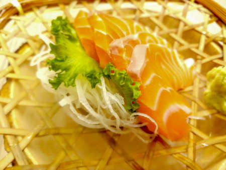 fresh sashimi salmon and lettuce served in a woven rattan dishの写真素材