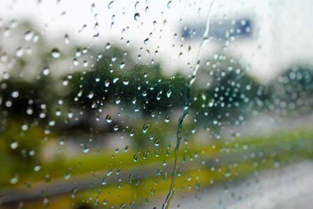Raindrops on the window show the weather in the rainy season.の写真素材