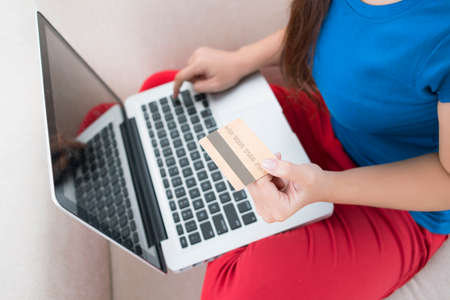 Young female paying for her online order by a credit cardの写真素材